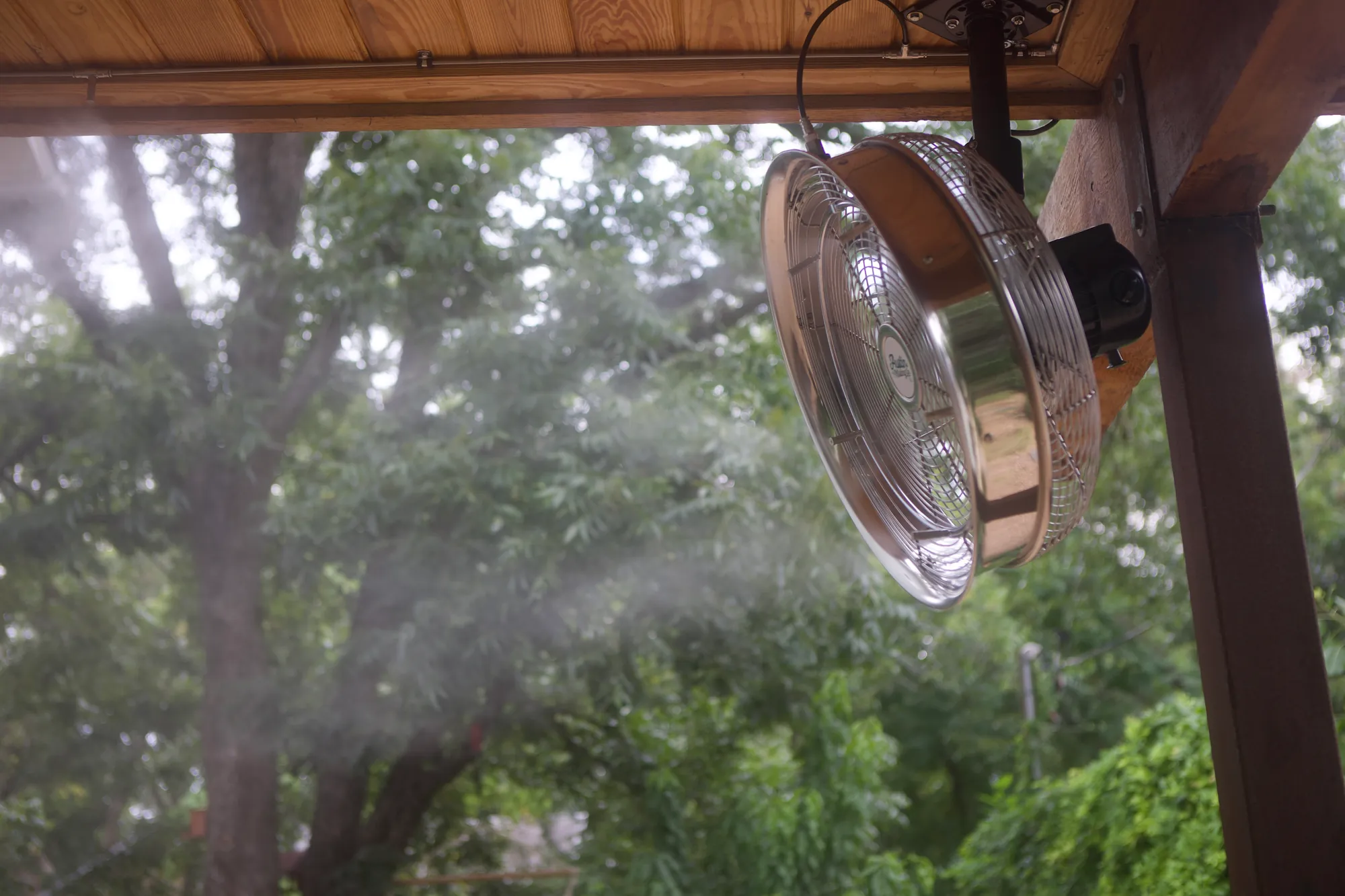 Ceiling-mounted misting fan on a covered deck