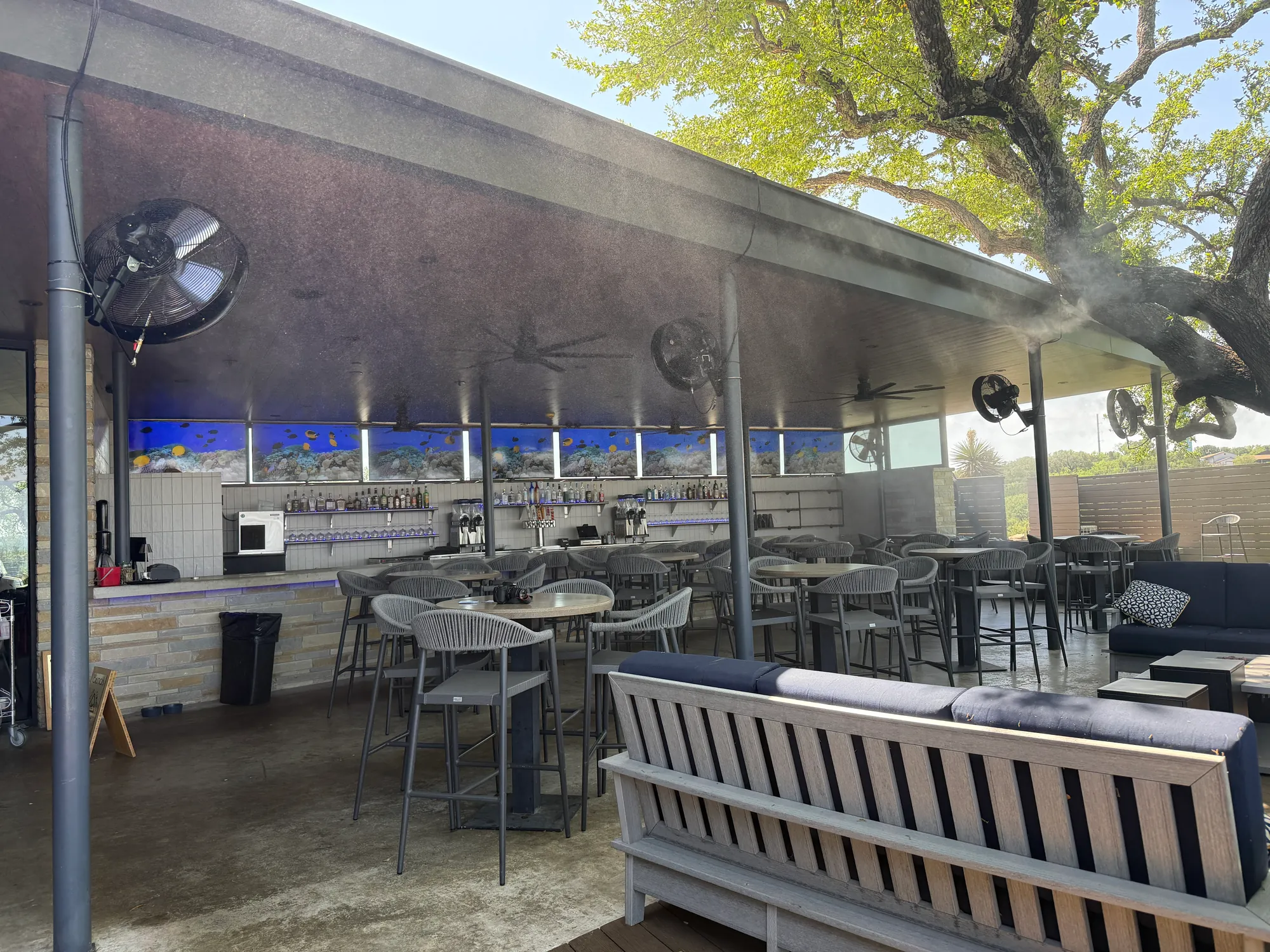Outdoor bar with misting fans on a covered patio