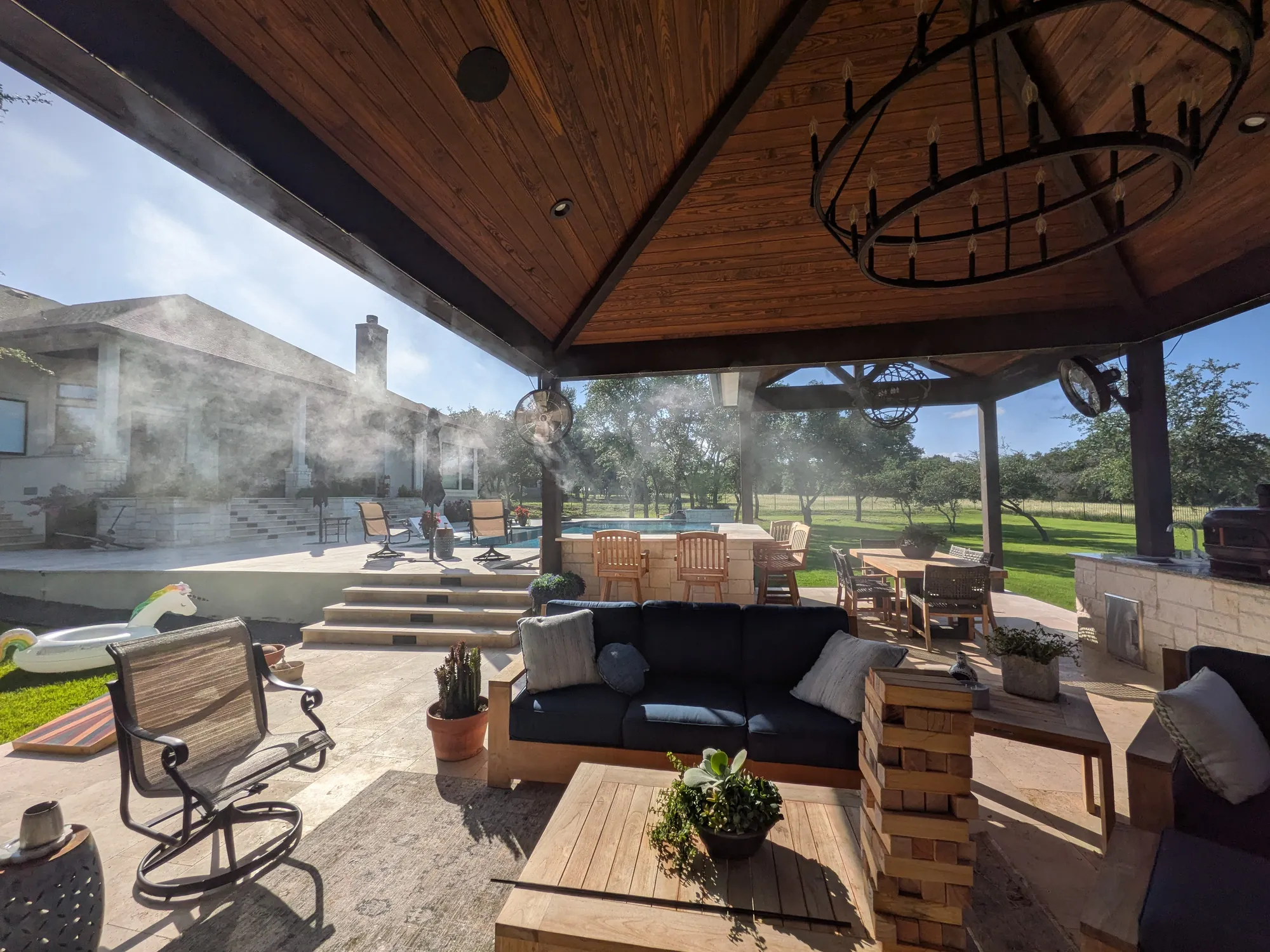 Outdoor pavilion misting fans by a pool in Austin