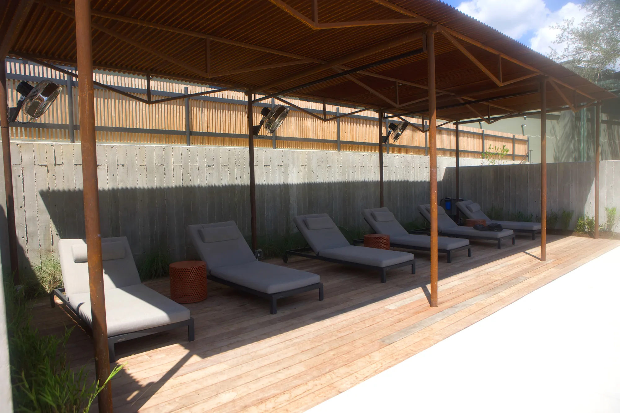 Poolside cabana misting fans over lounge chairs