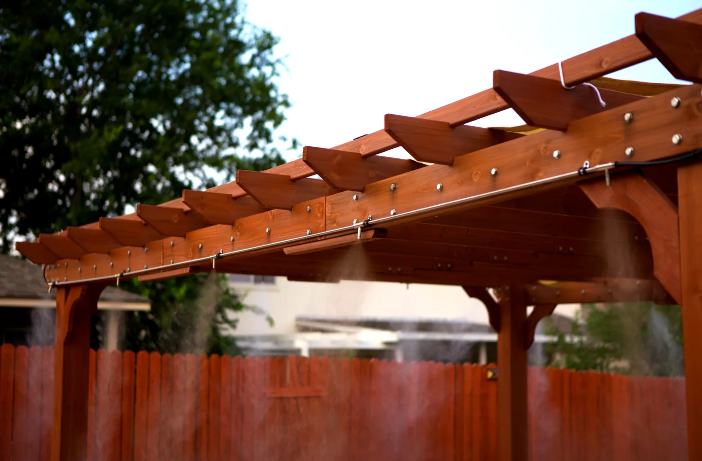 Close up of misting nozzles spraying mist on a residential pergola