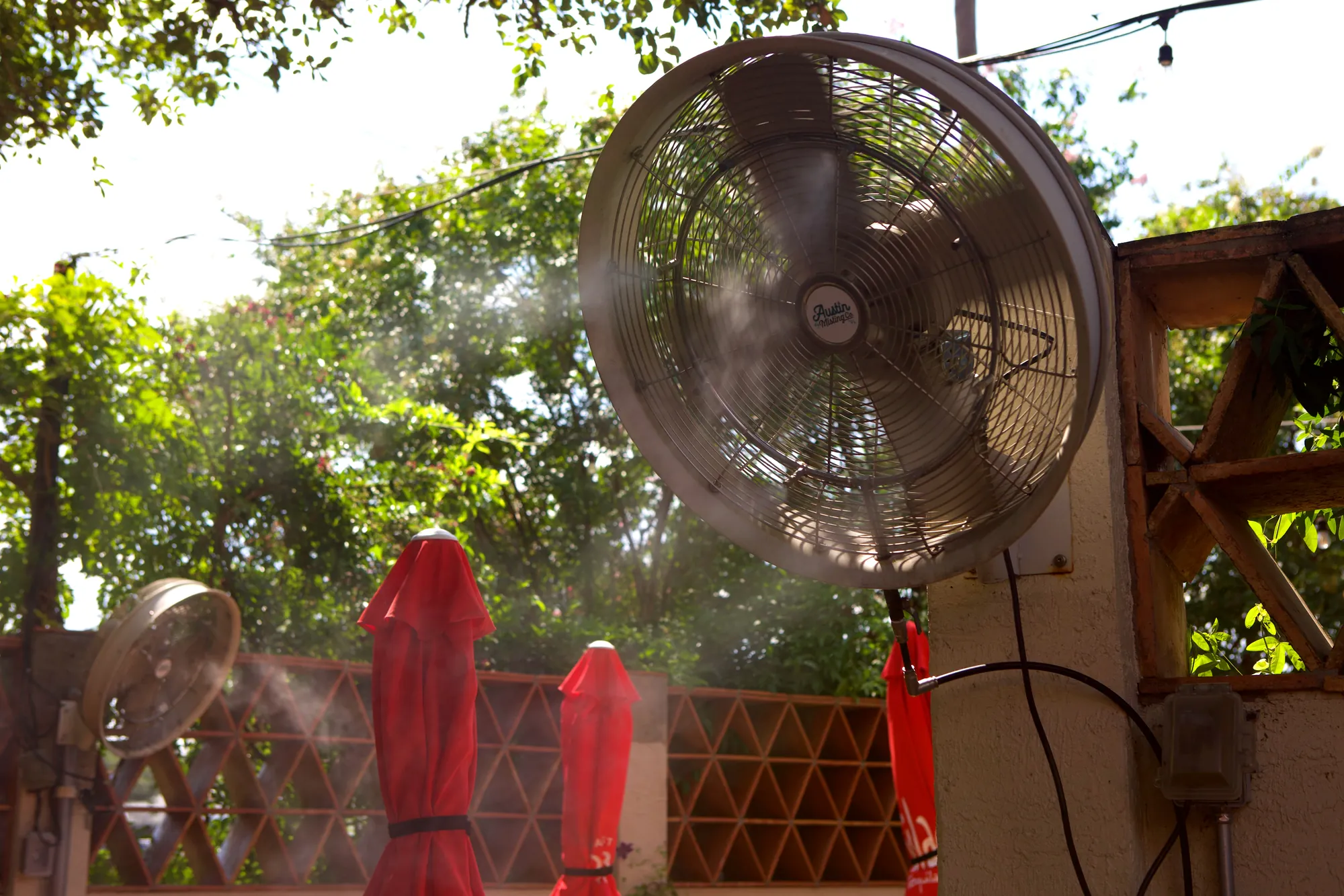 Wall-mounted misting fans on a restaurant patio